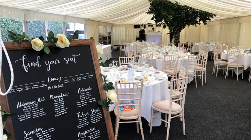 internal marquee shot showing tables and chairs in ivory and cream.